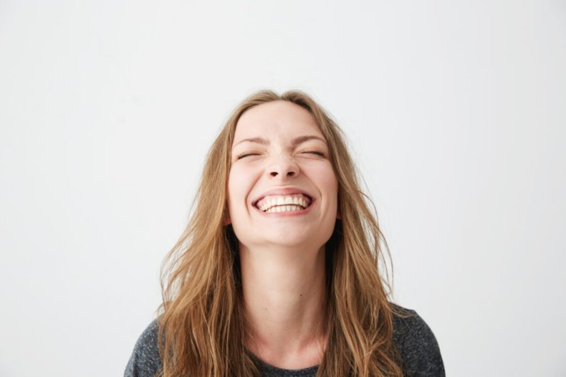 Mujer sonriendo con fondo blanco, imagen de sonrisa saludable para clínica dental en Tudela de Duero